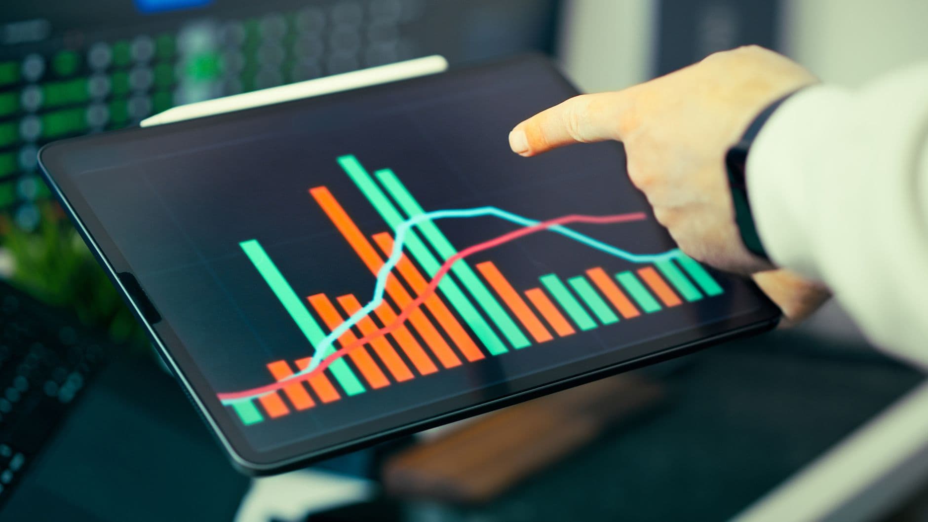 A person analyzing business data with colorful graphs on a tablet screen.