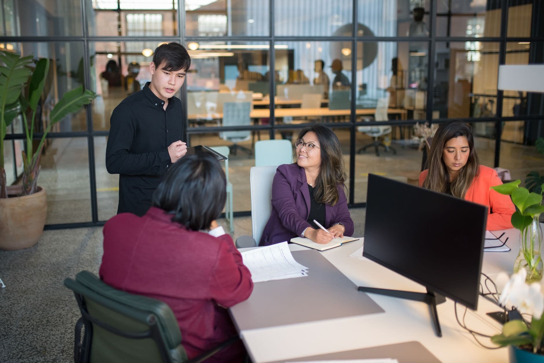 Colleagues engage in a meeting within a modern office, promoting teamwork and productivity.