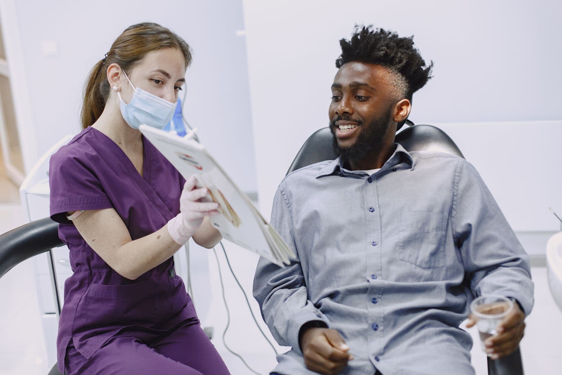 A dentist explains treatment options to a patient during a checkup.