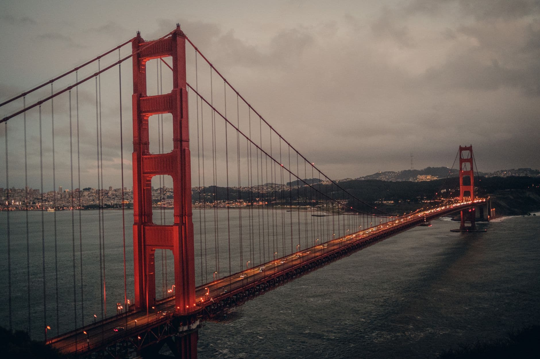 Stunning aerial view of the Golden Gate Bridge at twilight with city lights in San Francisco.