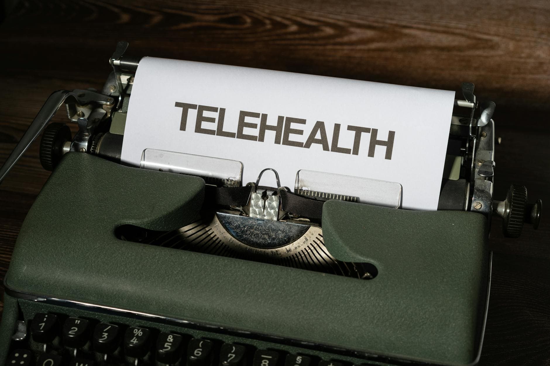 A vintage typewriter showcasing the word 'Telehealth' on paper, symbolizing modern healthcare.